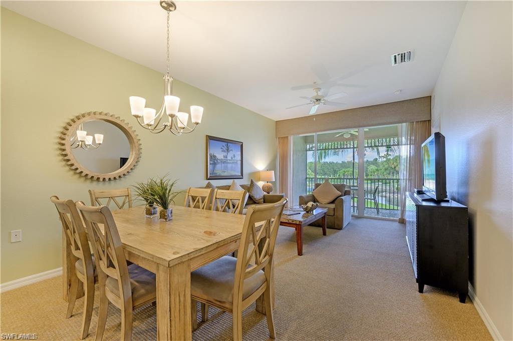 7940 Mahogany Run Lane, Unit 623 Naples, FL 34113 - Photo 8 of 25 a view of a dining room with furniture a chandelier and large windows