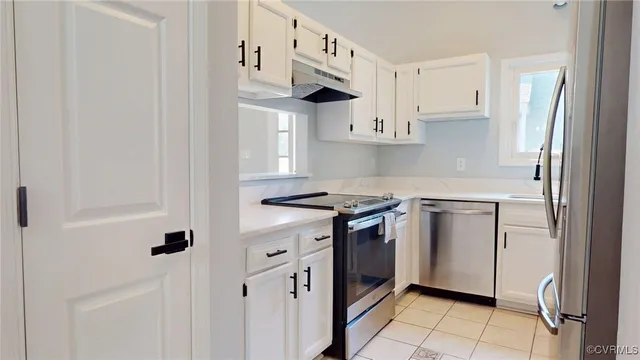 a kitchen with stainless steel appliances a refrigerator sink and cabinets