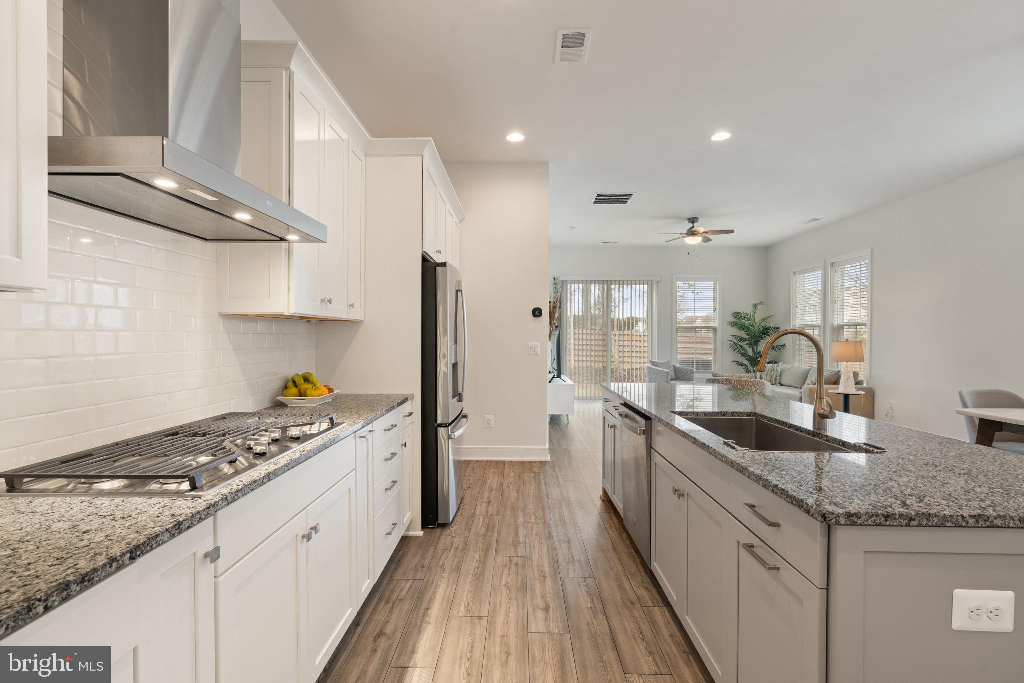 14712 Grand Cru Loop Gainesville, VA 20155 - Photo 12 of 46 a kitchen with granite countertop a sink stove and cabinets