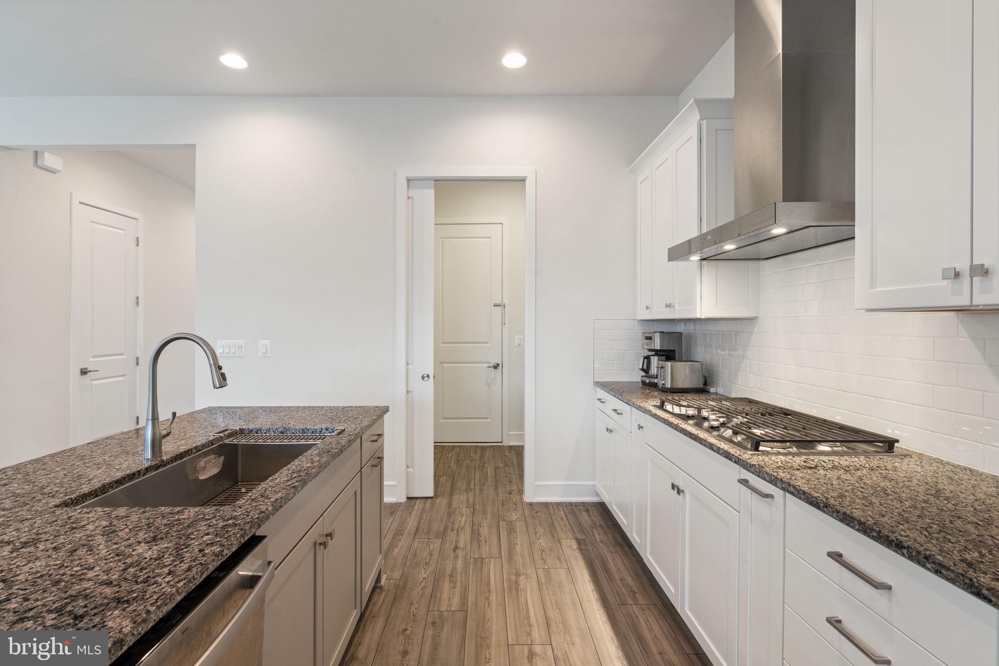 14712 Grand Cru Loop Gainesville, VA 20155 - Photo 13 of 46 a kitchen with stainless steel appliances granite countertop a sink stove refrigerator and cabinets