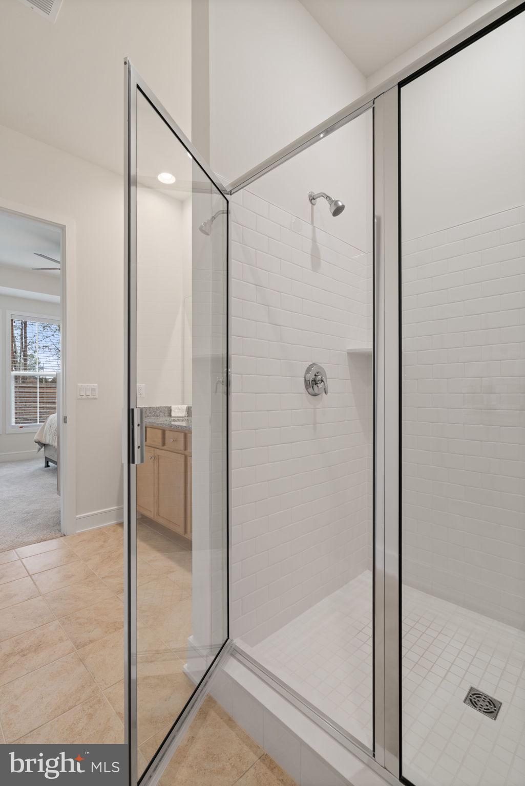 14712 Grand Cru Loop Gainesville, VA 20155 - Photo 19 of 46 a bathroom with a glass shower door
