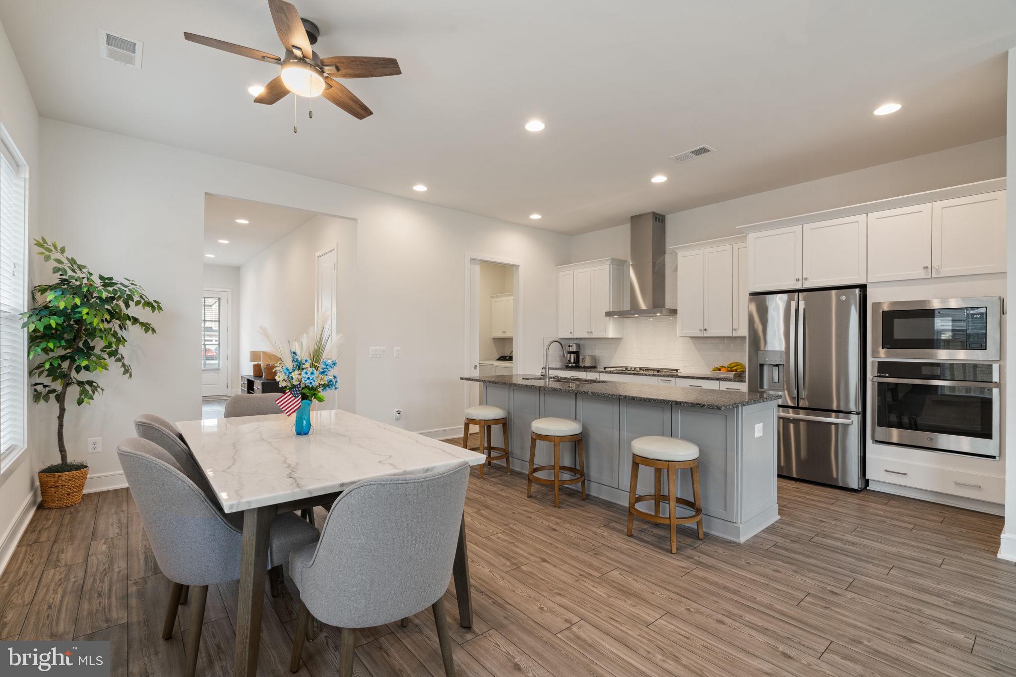 14712 Grand Cru Loop Gainesville, VA 20155 - Photo 5 of 46 a kitchen with a table and chairs in it