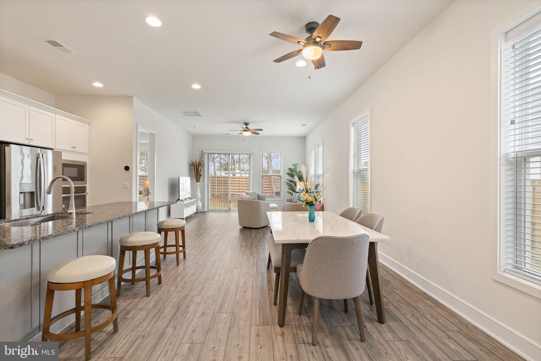 14712 Grand Cru Loop Gainesville, VA 20155 - Photo 7 of 46 a view of a dining room with furniture a chandelier and wooden floor