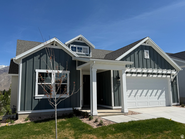 624 North Legend Circle, Unit 480 Mapleton, UT 84664 - Photo 2 of 34 View of front of home with roof with shingles, board and batten siding, a front yard, an attached garage, and driveway