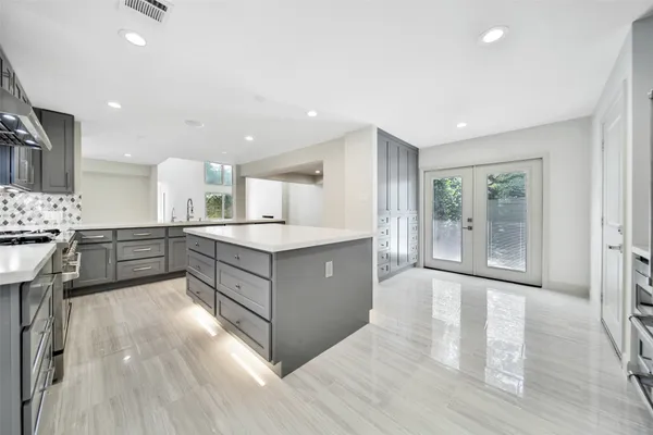 a large kitchen with kitchen island a sink stainless steel appliances and cabinets