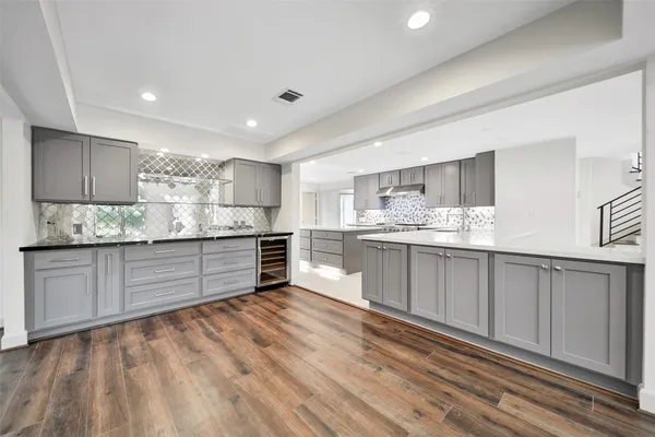 a large white kitchen with a large window appliances and cabinets