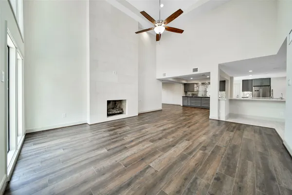 a view of a livingroom with wooden floor and a ceiling fan