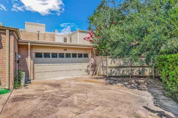 a front view of a house with garden and trees
