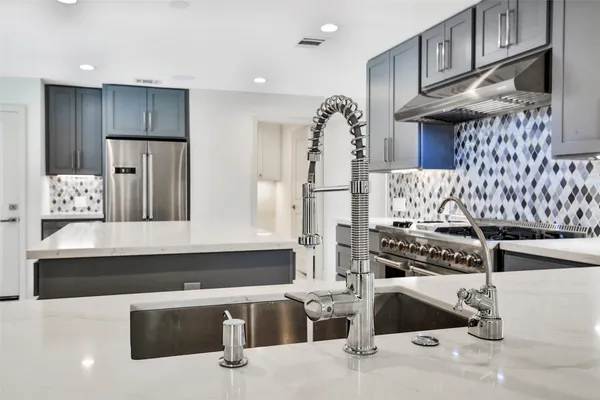 a kitchen with stainless steel appliances kitchen island granite countertop a refrigerator and a stove