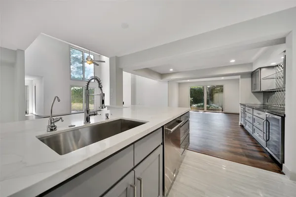 a kitchen with a sink and wooden floor