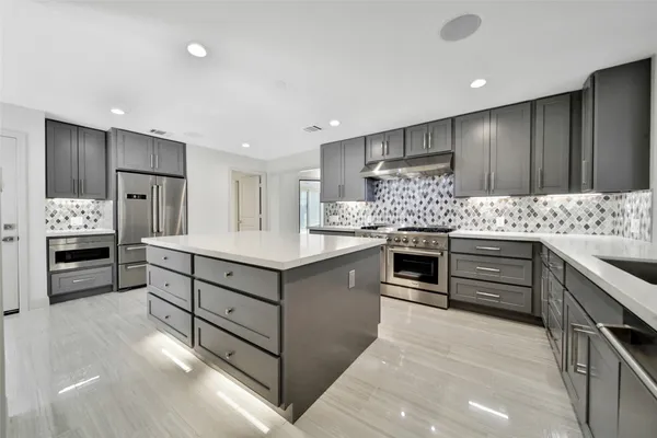 a kitchen with kitchen island cabinets and oven
