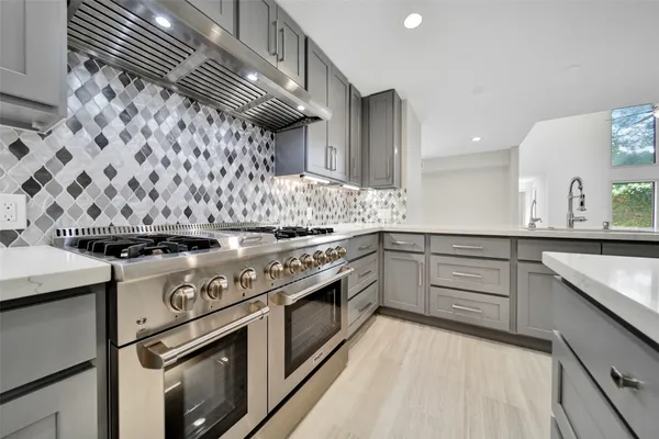 a kitchen with a stove top oven and cabinets