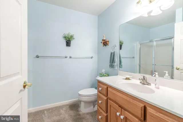 a bathroom with a granite countertop toilet a sink and a mirror