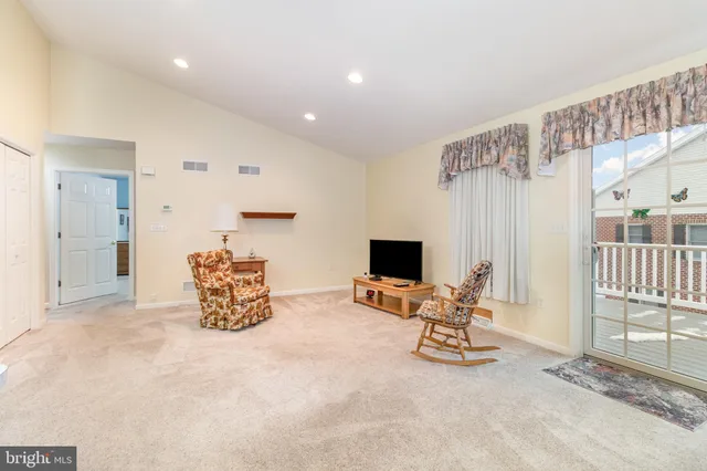 a view of a livingroom with workspace and a window