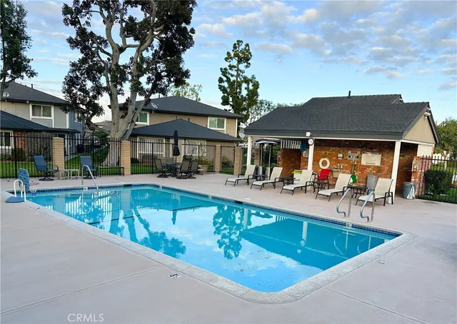 a view of house with swimming pool and outdoor seating