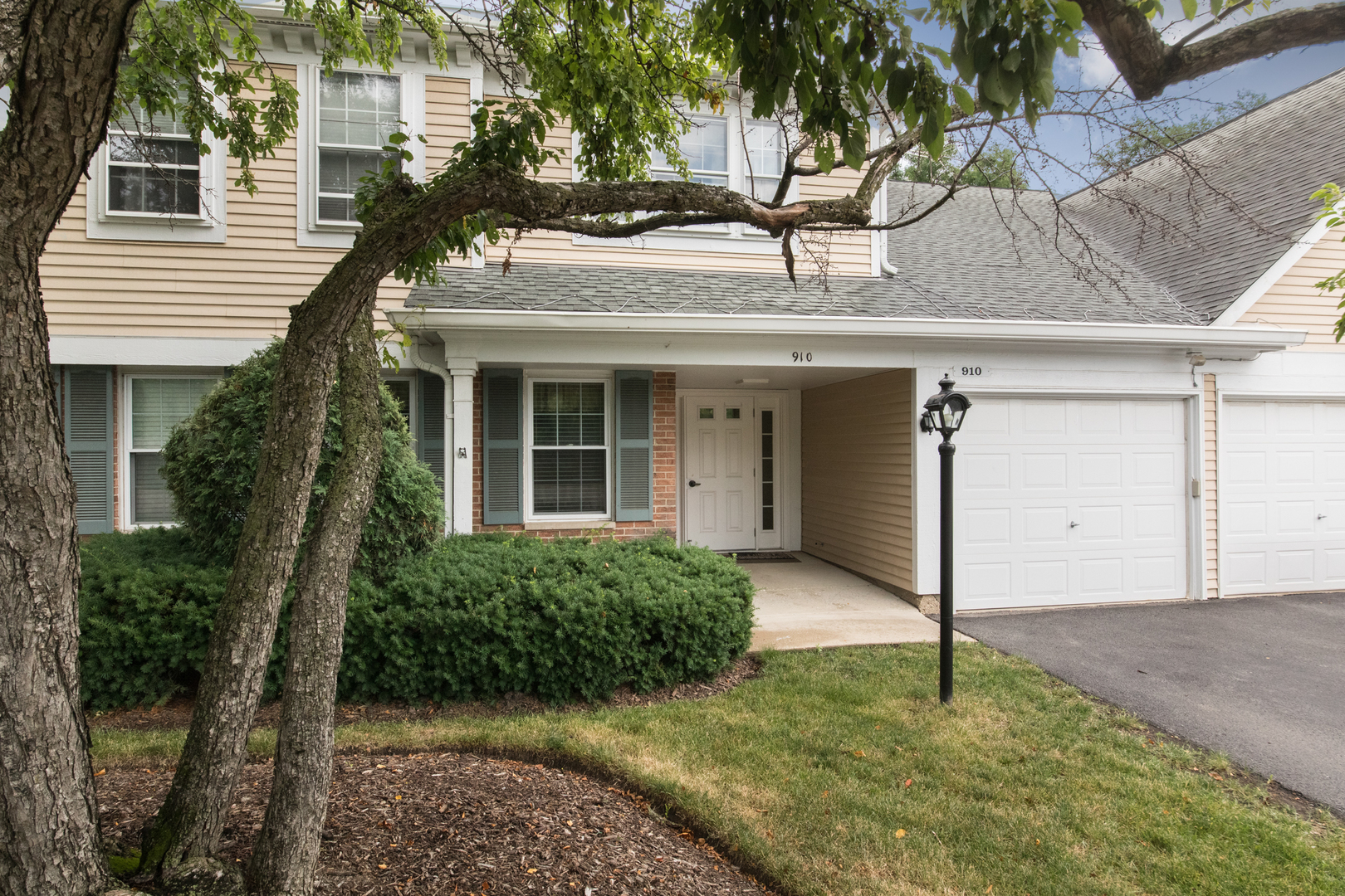 910 Persimmon Lane, Unit B Mount Prospect, IL 60056 - Photo 1 of 31 a house that has a tree in front of the house