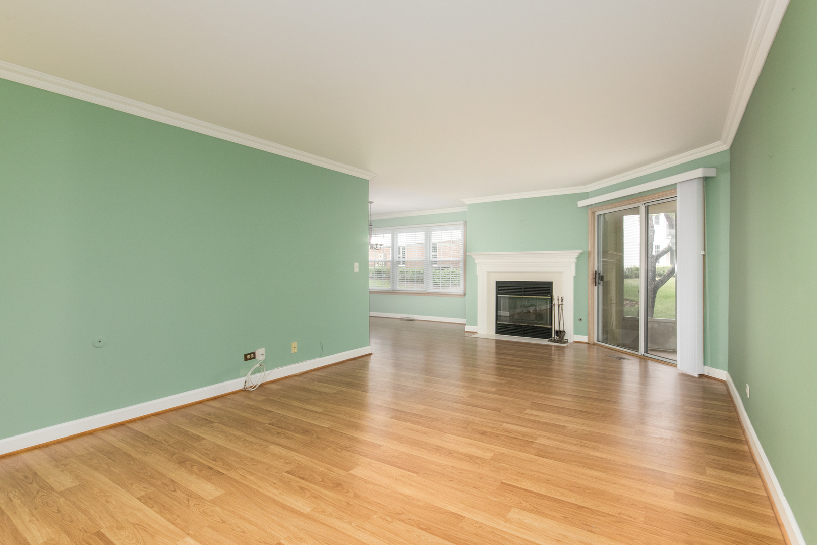 910 Persimmon Lane, Unit B Mount Prospect, IL 60056 - Photo 6 of 31 an empty room with wooden floor and fireplace