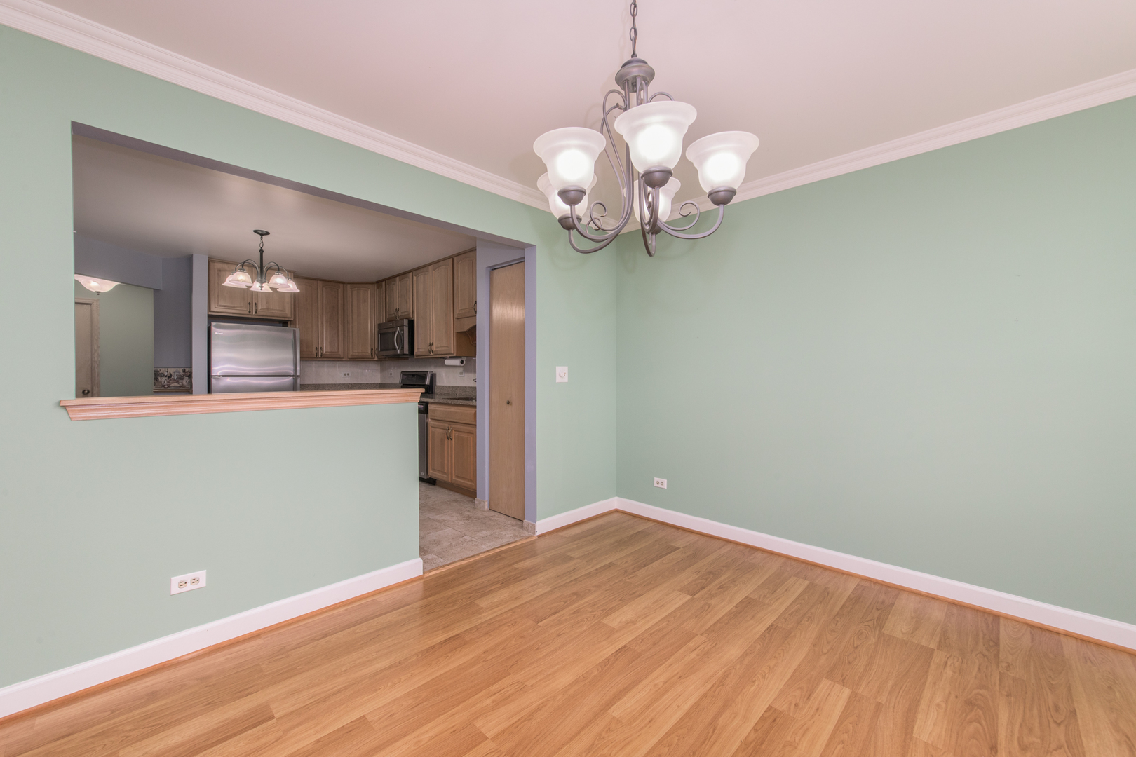 910 Persimmon Lane, Unit B Mount Prospect, IL 60056 - Photo 8 of 31 a view of a room with a chandelier and wooden floor