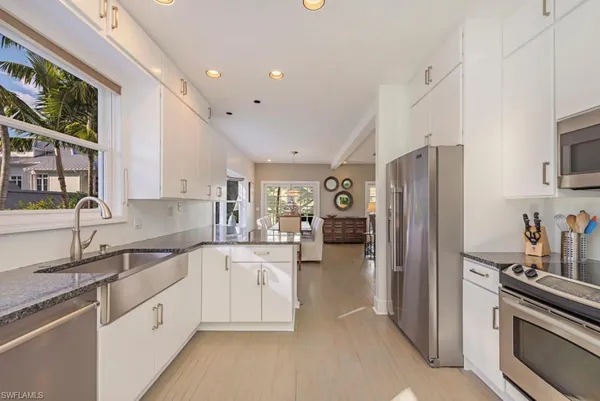 a kitchen with white cabinets and stainless steel appliances