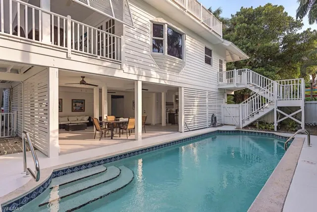 a view of a house with swimming pool and sitting area