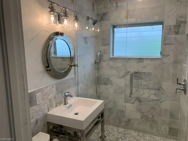a bathroom with a sink a mirror and a shower