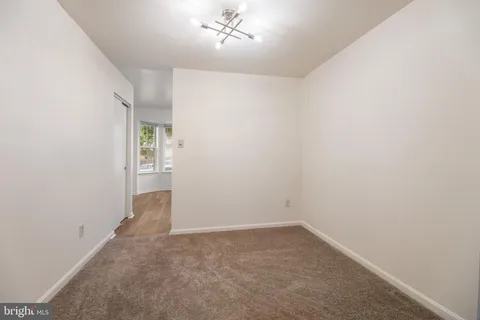 an empty room with a chandelier fan