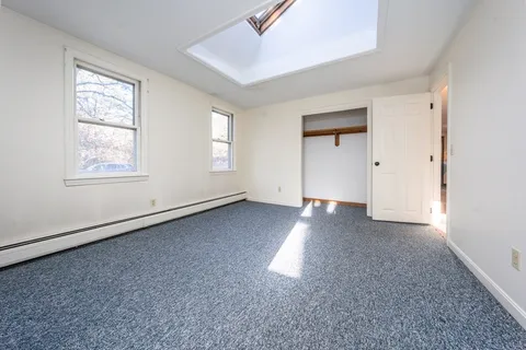 an empty room with windows and closet