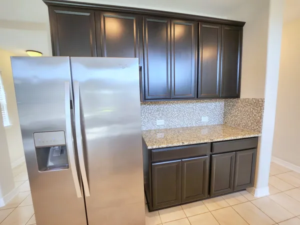 a view of a refrigerator in kitchen and stainless steel appliances wooden cabinet