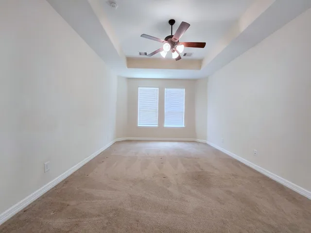 a view of an empty room with a chandelier fan