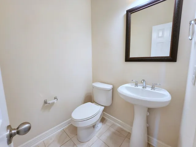 a bathroom with a sink mirror and toilet