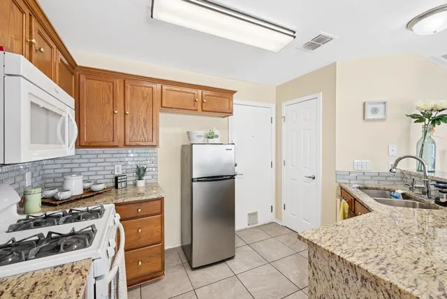 a kitchen with a refrigerator and a stove top oven