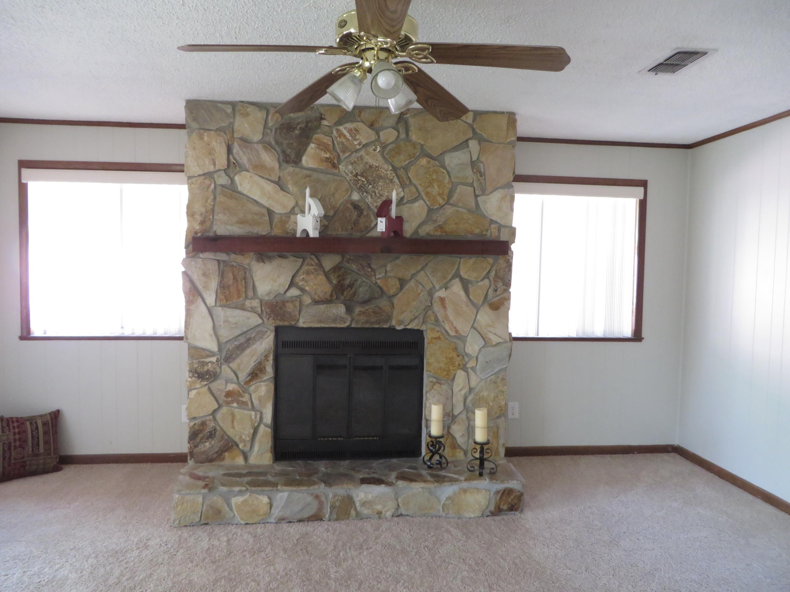 135 Perdido Circle Niceville, FL 32578 - Photo 12 of 28 a living room with a fireplace and a chandelier