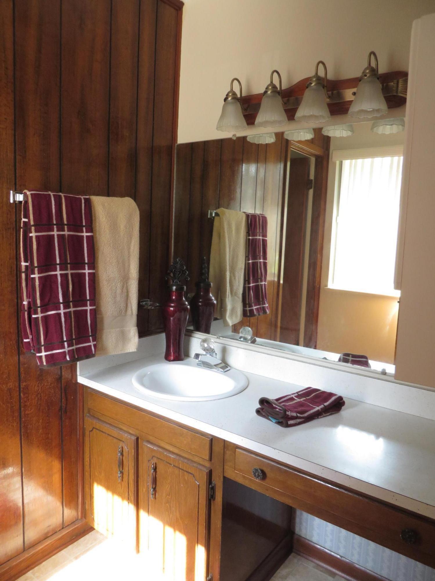 135 Perdido Circle Niceville, FL 32578 - Photo 19 of 28 a bathroom with a granite countertop sink and a mirror