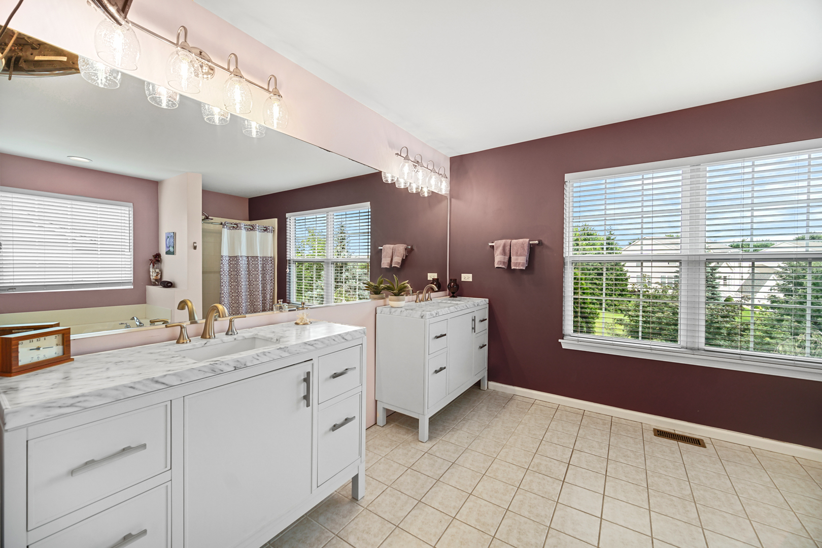 1826 Prairie Ridge Circle Lindenhurst, IL 60046 - Photo 16 of 39 a spacious bathroom with a double vanity sink a large mirror and a bathtub next to a window