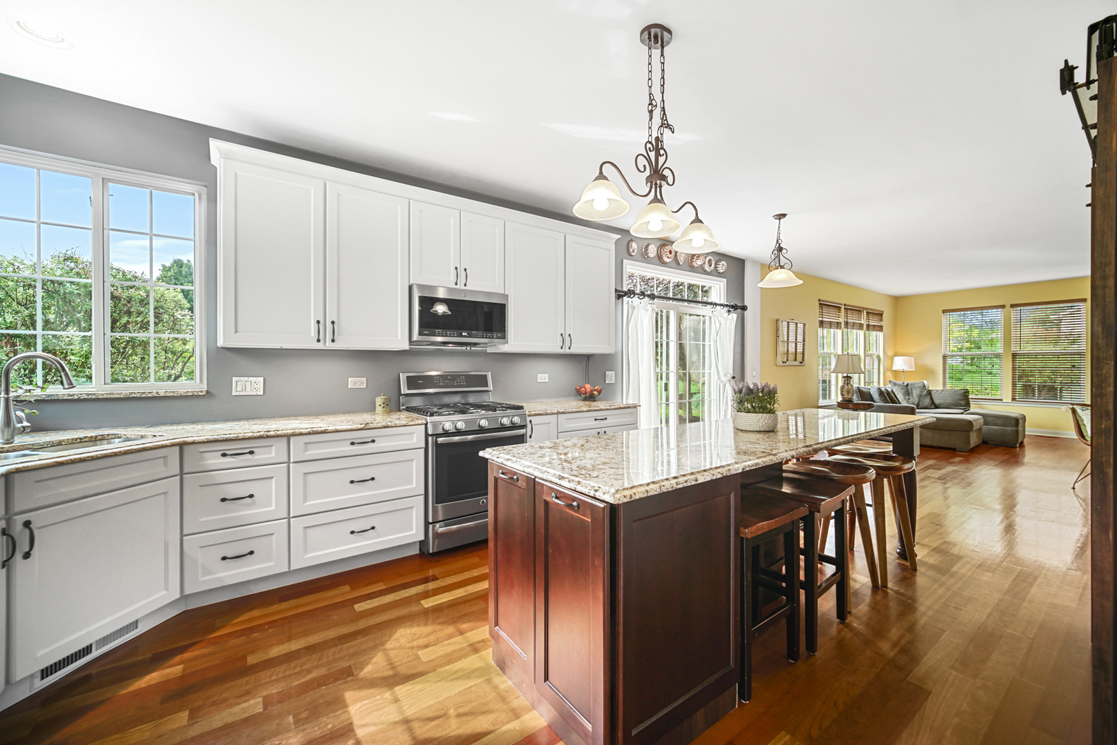 1826 Prairie Ridge Circle Lindenhurst, IL 60046 - Photo 7 of 39 a kitchen with stainless steel appliances granite countertop a stove top oven a sink dishwasher a dining table and chairs with wooden floor