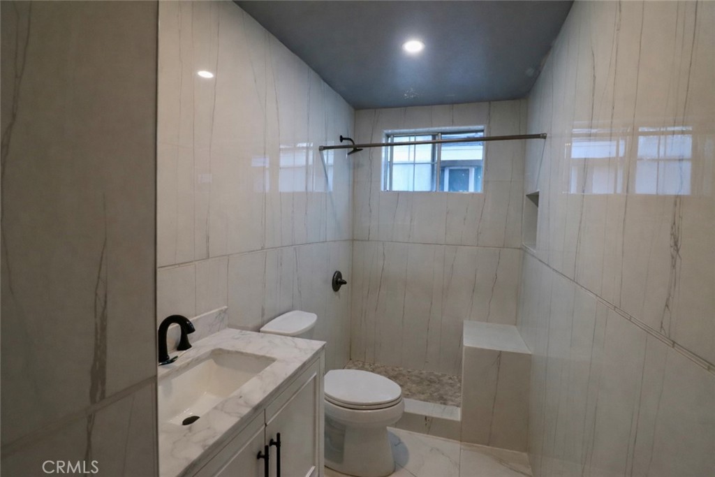 13438 Obispo Avenue Paramount, CA 90723 - Photo 6 of 14 a bathroom with a sink a toilet and shower