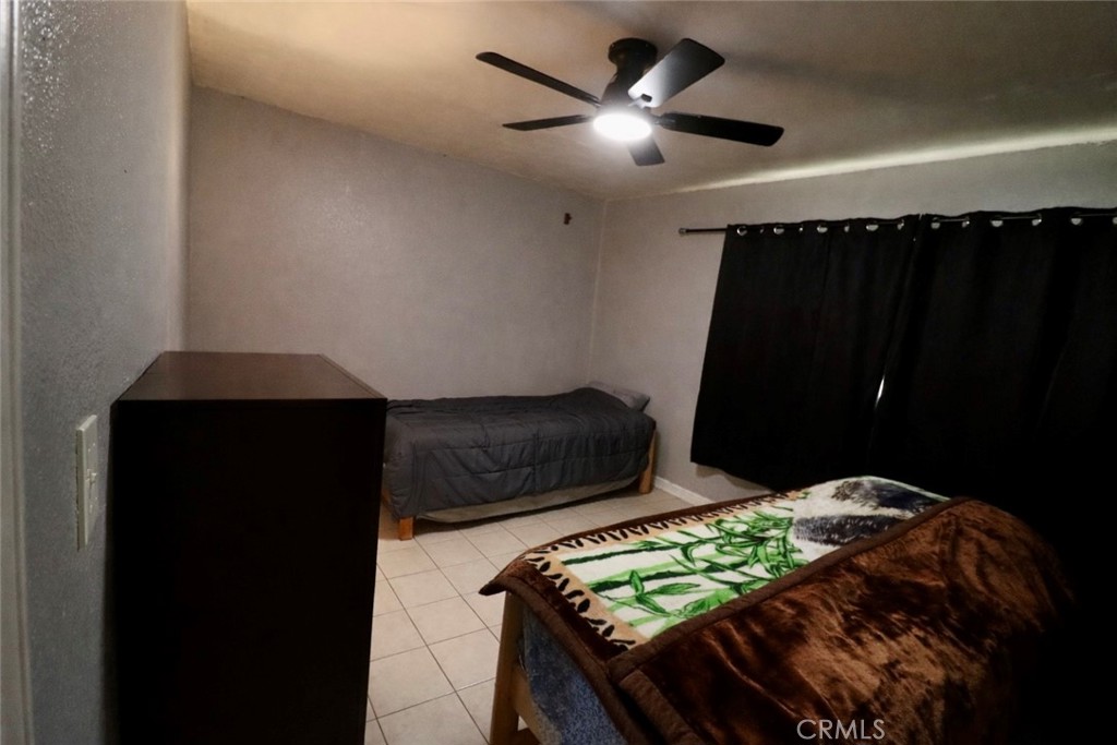 13438 Obispo Avenue Paramount, CA 90723 - Photo 10 of 14 a bedroom with a bed and a chandelier