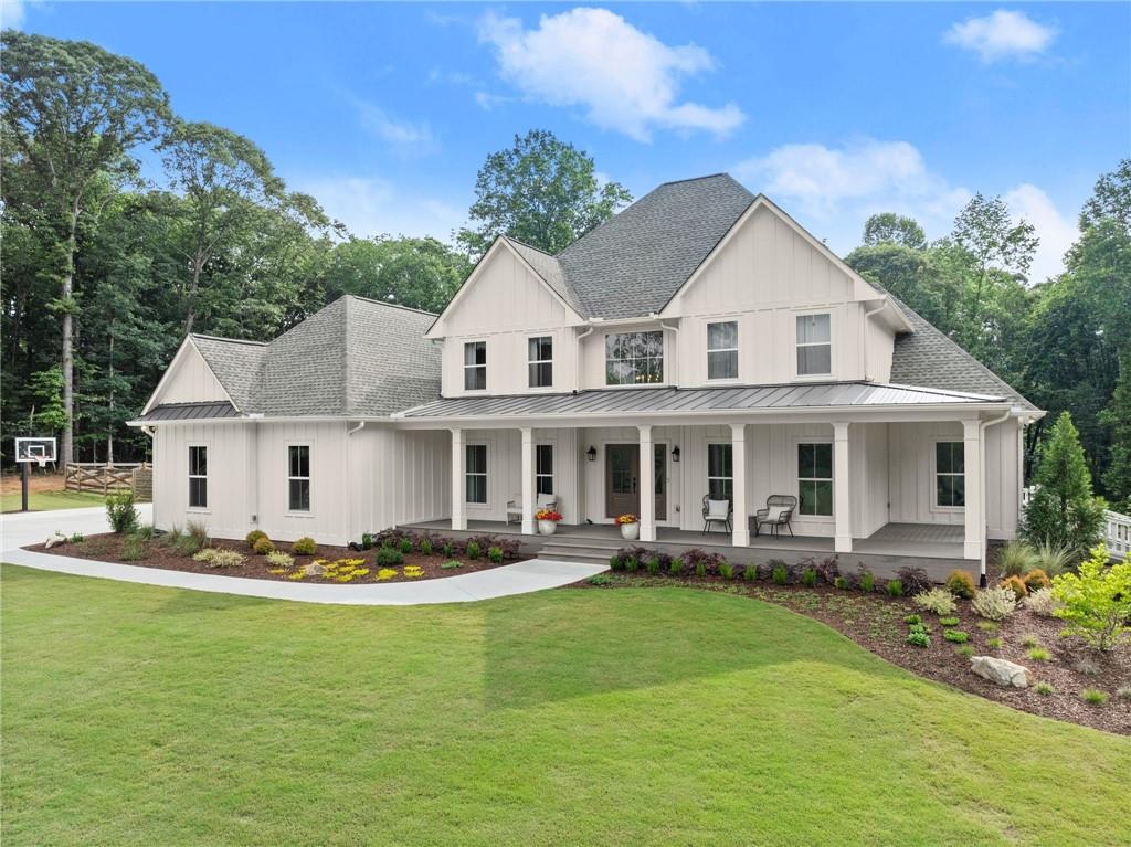 6998 Britt Gailey Road Clermont, GA 30527 - Photo 2 of 92 a front view of a house with a garden and trees