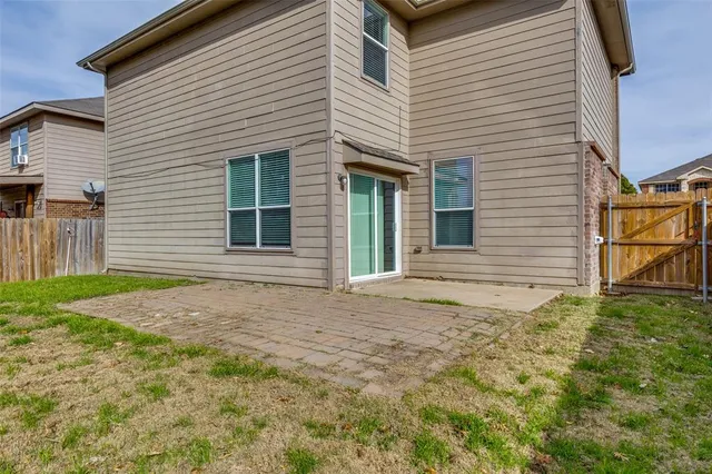 a front view of house with yard and trees in the background