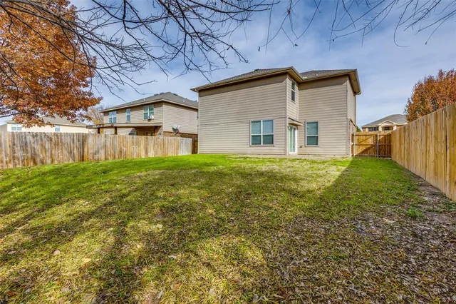 a view of backyard with wooden fence