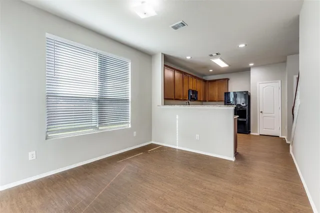 a kitchen with stainless steel appliances granite countertop a refrigerator a sink dishwasher a stove top oven and a refrigerator