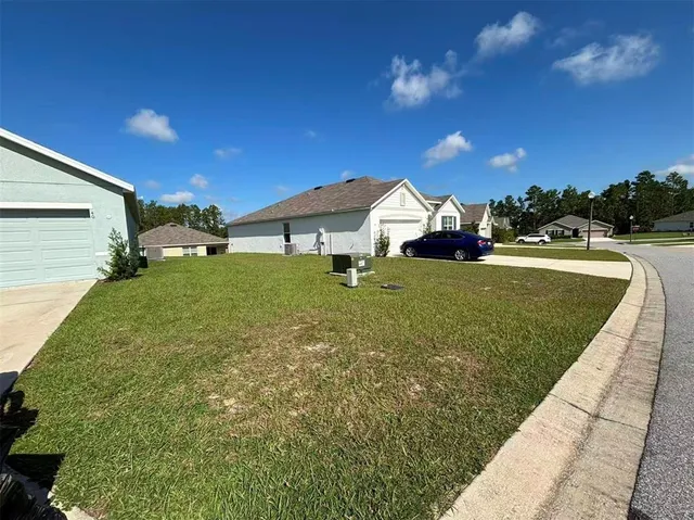 a view of a house with backyard and sitting area