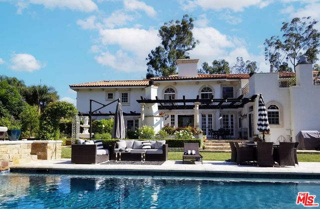 a view of house with swimming pool and furniture