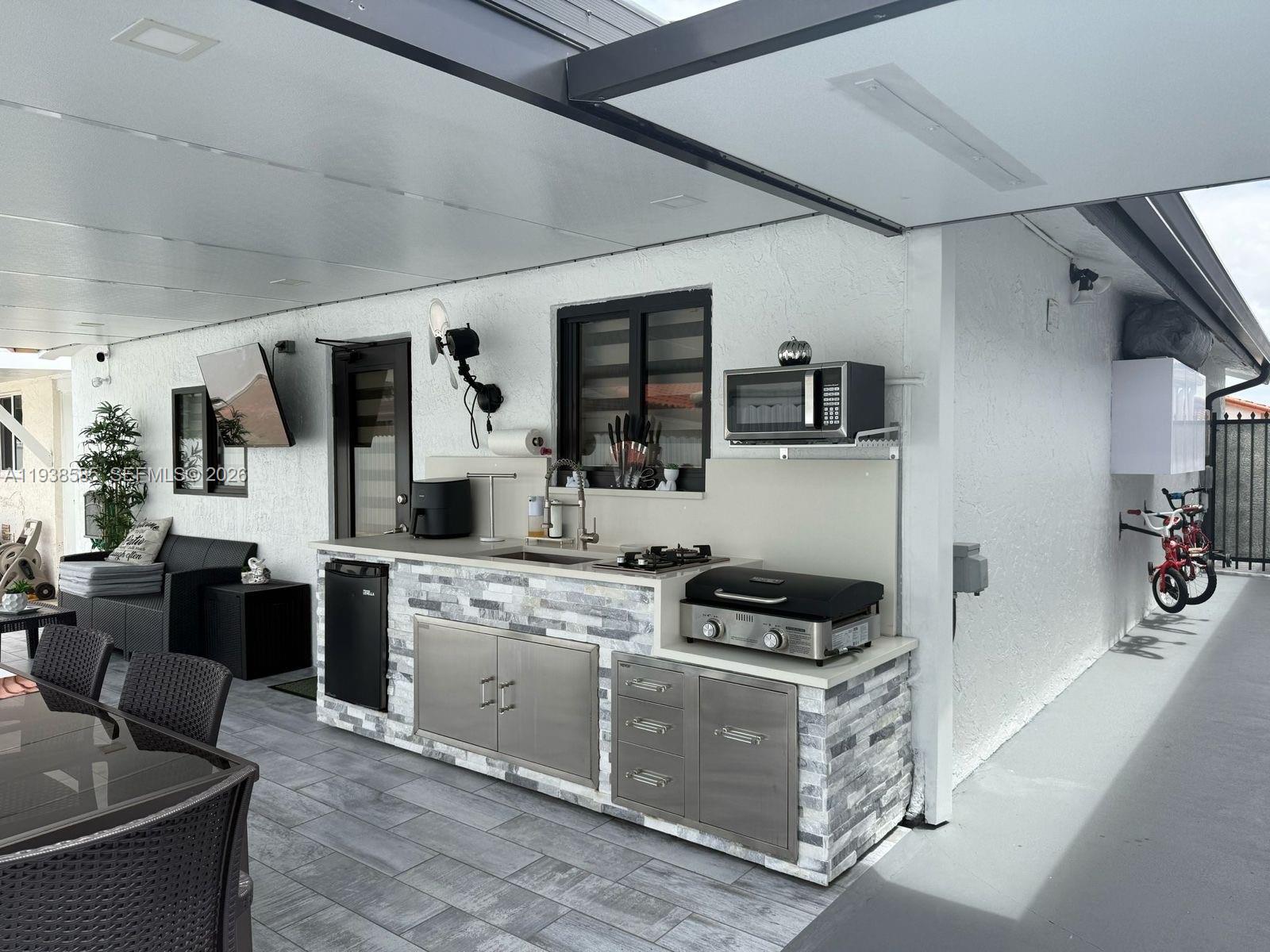 2837 West 75th Street Hialeah, FL 33018 - Photo 21 of 22 a kitchen with stainless steel appliances granite countertop a stove and a sink