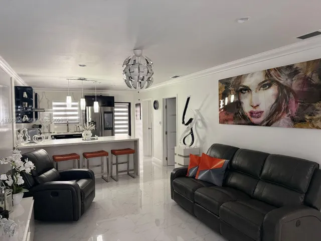 a living room with furniture a chandelier and a painting