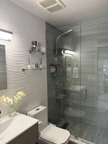 a bathroom with a sink toilet and mirror