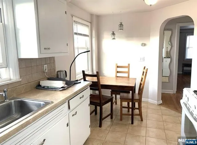 a kitchen with a table chairs sink and cabinets