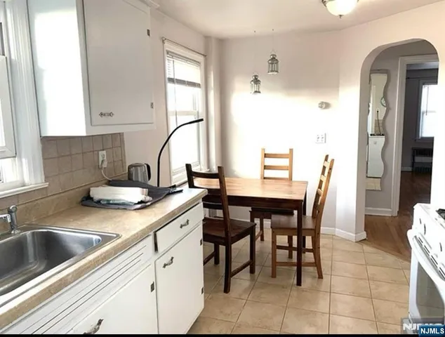 a kitchen with a white cabinets and chairs