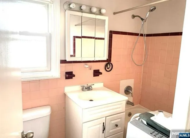 a bathroom with a sink a toilet and shower