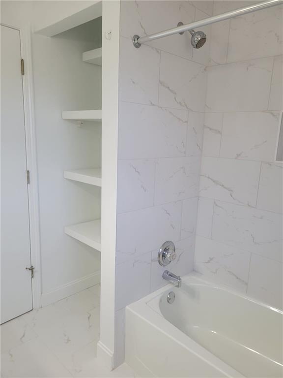 1063 Pleasant Hill Road, Unit A Lawrenceville, GA 30044 - Photo 15 of 18 a white bath tub sitting next to a shower